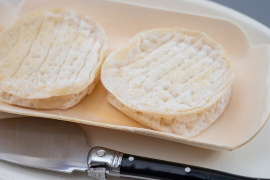 Rocamadour protected designation goat cheese from Occitanie region, France. Artisanal small-format soft cheese with creamy pale interior and natural rustic rind.
