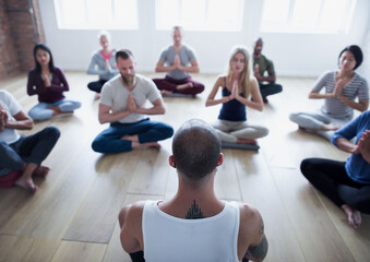 Fototapeta premium Diverse group of people in a yoga class doing a meditating pose
