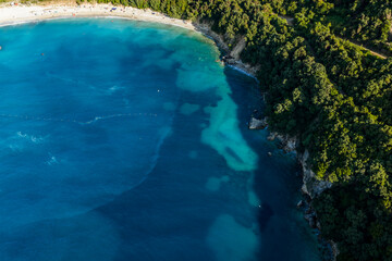 Fototapeta premium Kakome Beach aerial view of a secluded coastal cove with turquoise water, sandy beach, forest and rocky shoreline