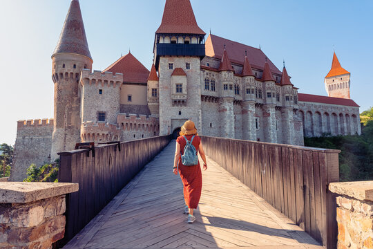 Woman tourist walking across the bridge toward Corvin Castle in Hunedoara Transylvania