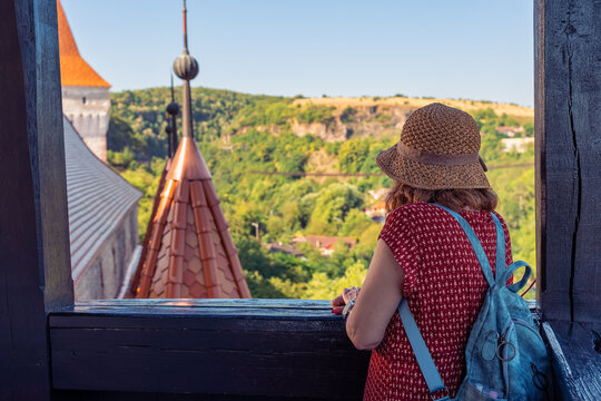Woman tourist with backpack looking at the landscape from Corvin Castle in Hunedoara Romania
