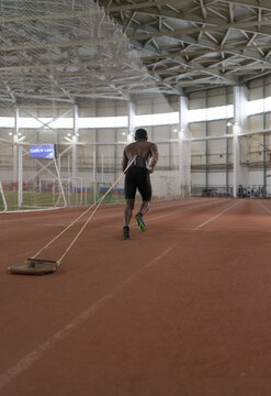 Unrecognizable African American runner pulling weight on track