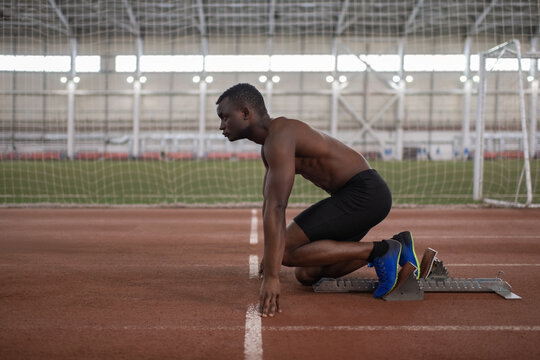 African American athlete in crouch start position during workout