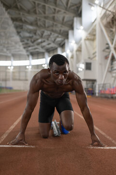 Determined African American athlete in crouch start position