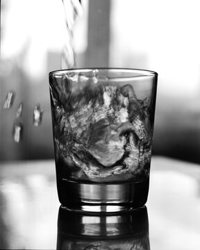 Dramatic Black and White Glass with Ice and Pouring Liquid