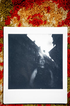 Polaroid portrait on colorful rug with light leak