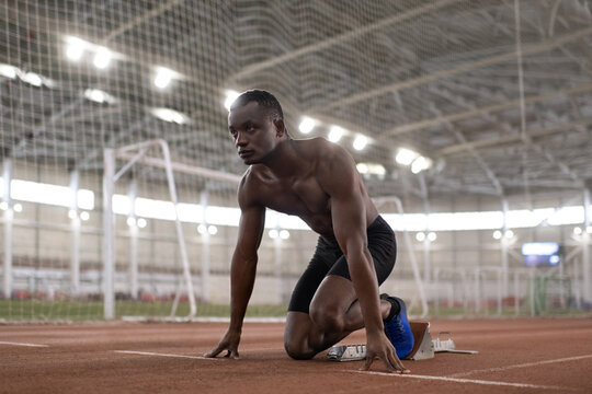 African American runner ready to sprint  from crouch start position