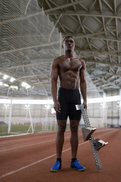 Black athlete with starting block ready to run