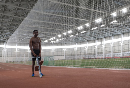 African American athlete preparing starting block