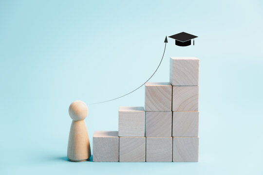 Education and career growth concept with wooden person, rising blocks, upward arrow and graduation cap, symbolizing academic progress, learning goals, achievement and future success.