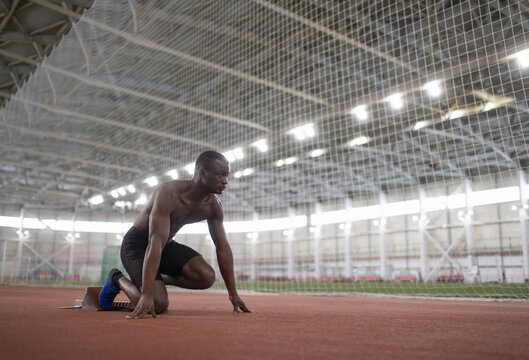African American athlete preparing to run  from couch start position