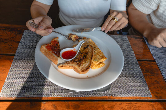 Enjoying breakfast with omelet, toast, and jam