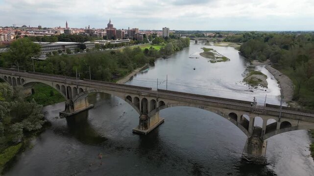 Milan &ndash; Pavia &ndash; Genoa railway line: drone view of a regional train and an Intercity train crossing the bridge over the Ticino River in Pavia, Italian Railways and the modernization of the rail network