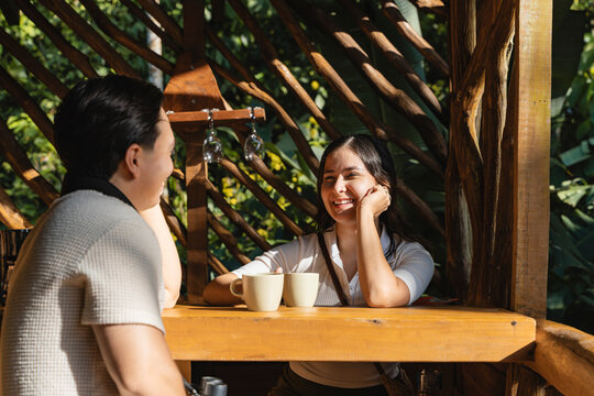 Happy couple enjoying coffee conversation in outdoor resort