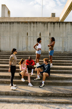 General shot of morning runners gathered on park stairs.