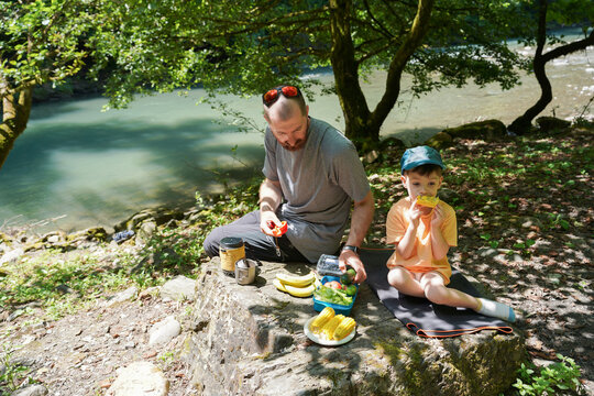 Father And Son Had A Picnic In The Forest By The River