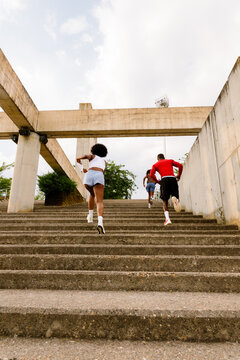 A group of runner friends climbing a staircase
