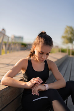 Sportive female using smart watch outdoors