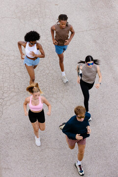 Full-body shot from above of a group of fitness enthusiasts running