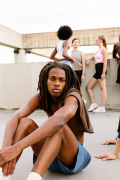 Full-body portrait of an athlete resting with friends.