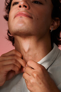 Young Man Adjusting jacket Against a Pink Background