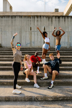 Full-body portrait of sports enthusiasts waving at the camera.