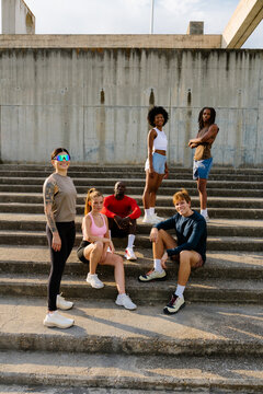 Group of runner friends posing on a staircase in a public park