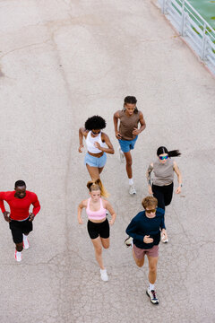 Overhead full-body shot of fitness enthusiasts working out in a park.