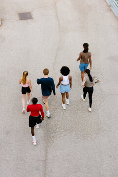 High-angle wide shot of active friends walking together in a park.