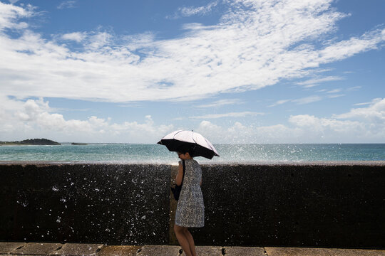 Woman With Parasol Beside Crashing Ocean Waves