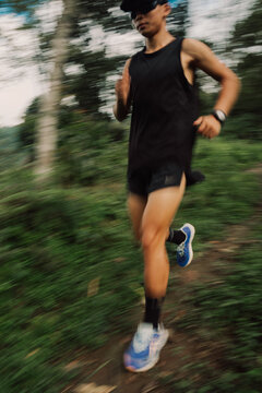 Runner Moves Through a Forest Trail During the Day