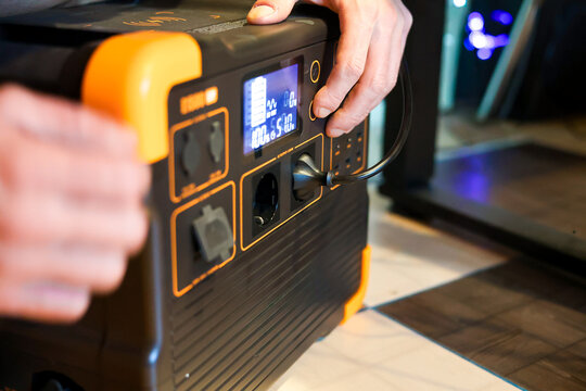 Blackout concept. A man connecting a charging station for work during a power outage.  blackout, working from a battery. Portable power station
