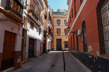 Fototapeta premium Narrow historic street lined with balconied buildings in Seville old town