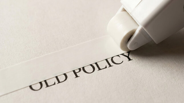 Old policy document with correction roller covering printed text, close up office editing scene