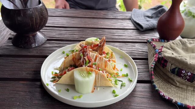 Seafood tacos and omelet served on wooden table at outdoor cafe in Sri Lanka