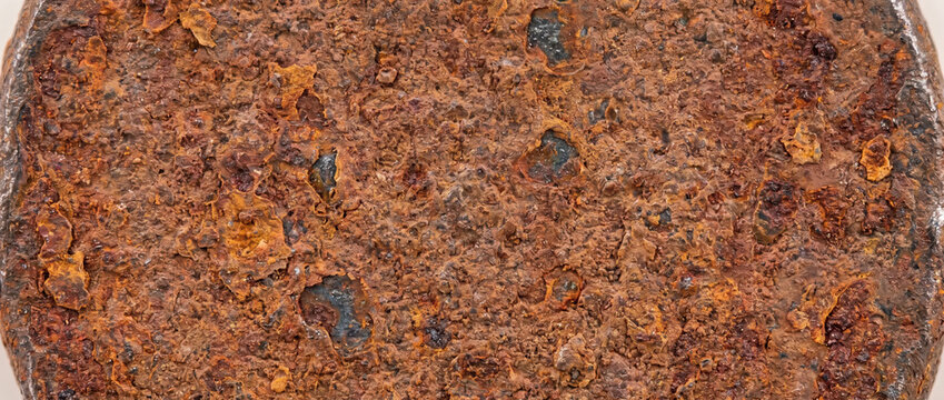 Rusted iron nail head texture with heavy corrosion and pitting. Weathered metal fastener background