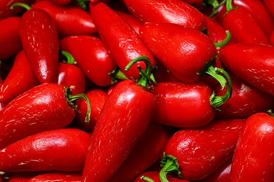 close-up of fresh red chili peppers with green stems, vibrant color and smooth texture, healthy spicy vegetable