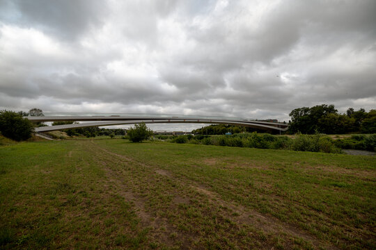 Poznan, Poland - July 8, 2026: The modern Berdychowskie Bridge forms sweeping lines above the Warta River floodplain.