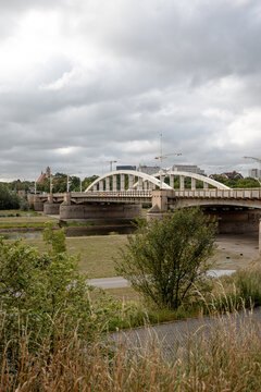 Poznan, Poland - July 8, 2026: White steel arches of Saint Roch Bridge span the Warta River, partially framed by trees along the riverfront.
