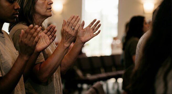 Raised hands during Christian church worship service. Believers praising and praying in sanctuary background