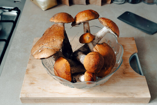 Close-up of a glass bowl filled with ripe red cap bolete mushrooms (Leccinum aurantiacum). 