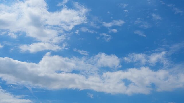 A blue sky cloud timelapse video showing scattered cumulus and altocumulus clouds drifting in sunlight, capturing gentle wind, atmospheric motion, fresh air, and naturally changing daytime weather.
