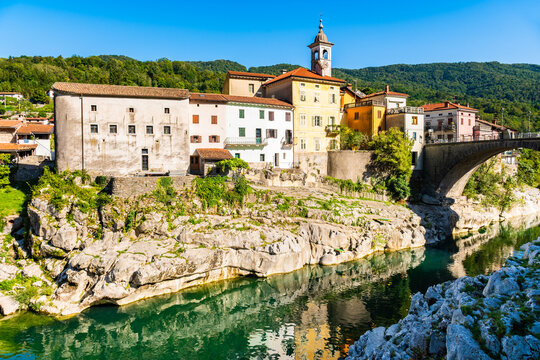Colorful historic houses and a stone bridge along the emerald Soca River in the picturesque town of Kanal ob Soci, Slovenia
