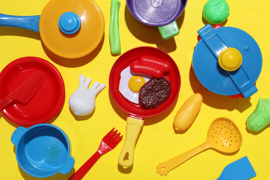 Toy cooking utensils, kids kitchen play set with food products on yellow background