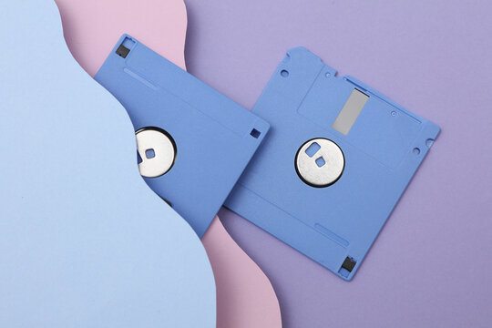 Vntage floppy disks from 80s on cut paper background of wavy layers. Retro wave. Creative layout. Minimalism