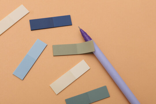 Set of colored paper stickers and pen on pastel background. Business concept.
