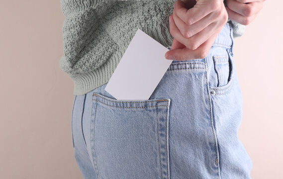 Blank white business card in back pocket of blue jeans on a woman