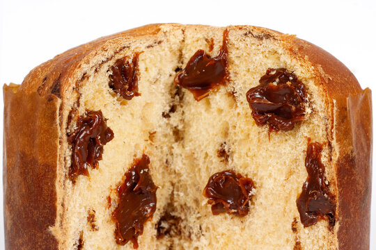 Sliced Christmas chocolate panettone with creamy filling, isolated on a white background.