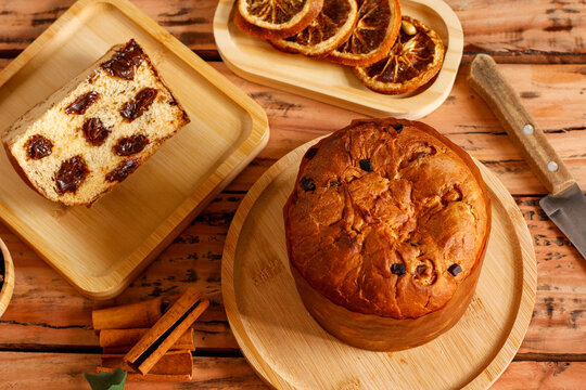 Festive chocolate panettone displayed on a rustic wooden table decorated for a Christmas celebration.