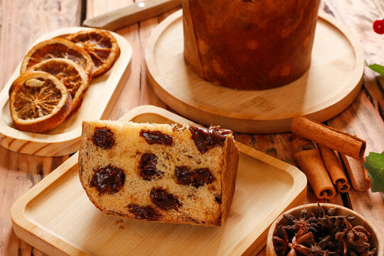 Traditional chocolate panettone presented as a festive dessert on a decorated rustic wooden table.